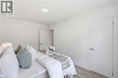 White walls with wood-finish flooring, two panel doors, and flush-mount ceiling lighting - 156 East 36Th Street, Hamilton, ON - Indoor Photo Showing Bedroom
