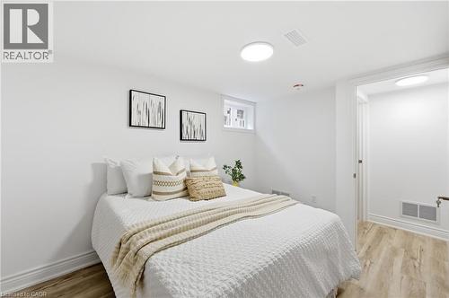 Recessed window, wood-finish flooring, white walls, white trim, and ceiling-mounted lighting fixtures - 156 East 36Th Street, Hamilton, ON - Indoor Photo Showing Bedroom