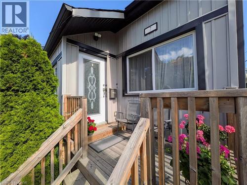 Front exterior featuring light-colored vertical siding and dark trim - 7 Campbell Avenue, Hamilton, ON - Outdoor