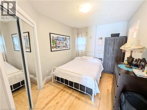 Hardwood flooring throughout, mirrored closet doors, neutral wall tones, and recessed lighting - 7 Campbell Avenue, Hamilton, ON - Indoor Photo Showing Bedroom