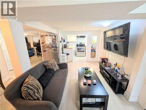 Light wood-finish flooring, recessed ceiling lighting, stainless steel appliances, and built-in shelving - 7 Campbell Avenue, Hamilton, ON - Indoor Photo Showing Living Room