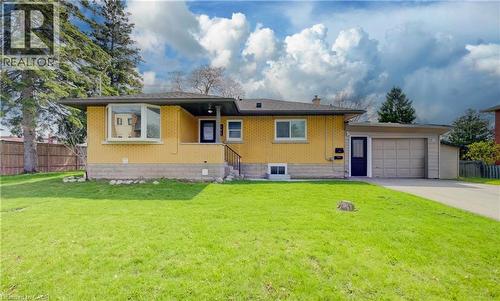 Single-story residence featuring yellow brick facade, bay window, covered front entry, attached garage, and a spacious front lawn - 361 Prospect Avenue, Kitchener, ON - Outdoor