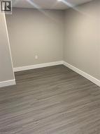 Interior room with neutral-toned walls, wood-finish flooring, white trim, and recessed lighting - 