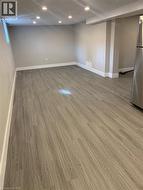 Spacious room featuring wood-finish flooring, recessed ceiling lighting, a window, and neutral wall paint - 
