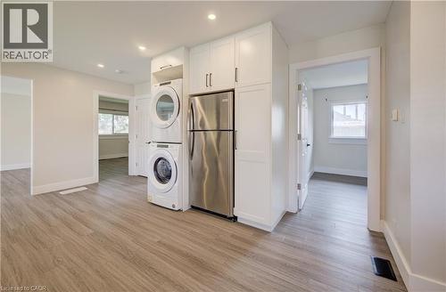 Laundry area with stacked appliances, white cabinetry, and stainless steel refrigerator - 361 Prospect Avenue, Kitchener, ON - Indoor Photo Showing Other Room