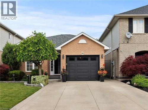 Brick facade with a dark shingle roof, a two-car garage, and a concrete driveway - 40 Bridgette Drive, Hamilton, ON - Outdoor
