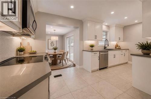 White shaker cabinetry, stainless steel appliances, tile flooring, recessed lighting, and a herringbone tile backsplash - 244 Royal Street, Waterloo, ON - Indoor Photo Showing Kitchen