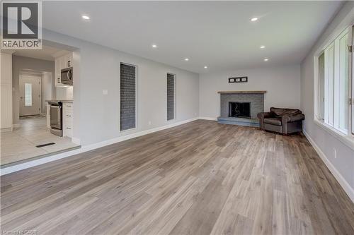 Spacious living area featuring wood-finish flooring, recessed lighting, and a stone-clad fireplace - 244 Royal Street, Waterloo, ON - Indoor Photo Showing Living Room With Fireplace