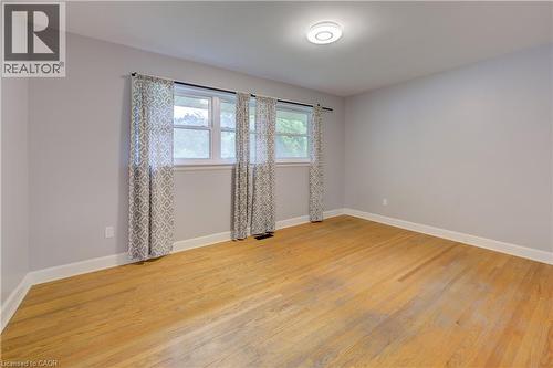 Wood-finish flooring, light gray wall paint, and multiple windows - 244 Royal Street, Waterloo, ON - Indoor Photo Showing Other Room