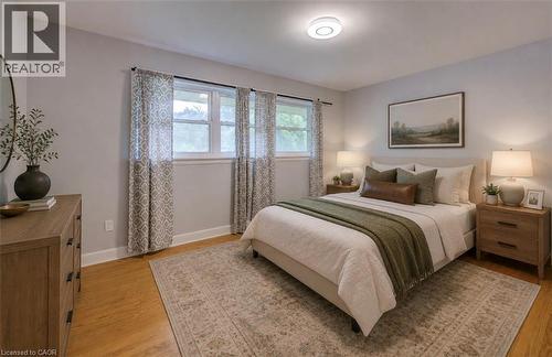 Hardwood flooring, light gray wall color, multiple windows, built-in ceiling light, and a light-colored area rug - 244 Royal Street, Waterloo, ON - Indoor Photo Showing Bedroom