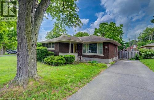 Brick exterior with white trim, covered front porch, and mature trees - 244 Royal Street, Waterloo, ON - Outdoor