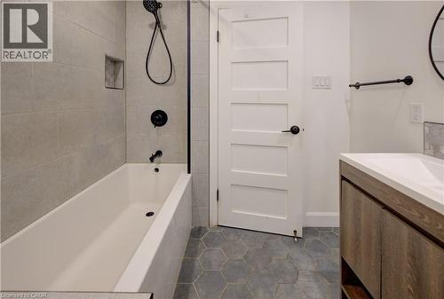 Contemporary bathroom featuring a tub with matte black fixtures, an in-shower niche, and hexagonal floor tiling - 244 Royal Street, Waterloo, ON - Indoor Photo Showing Bathroom