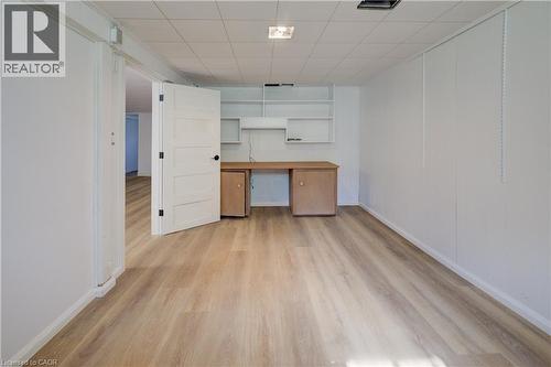 Wood-finish flooring, built-in desk, built-in shelving, white paneling, and a drop ceiling - 244 Royal Street, Waterloo, ON - Indoor Photo Showing Other Room