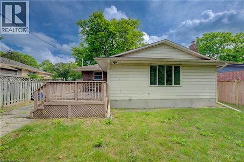 Rear exterior featuring a wooden deck with lattice skirting, light-colored siding, and a brick chimney element - 244 Royal Street, Waterloo, ON - Outdoor With Deck Patio Veranda With Exterior