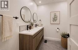 Dual vanity with wood-finish cabinetry, white countertop, and matte black fixtures - 
