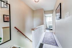Light-toned wood-finish flooring, white painted walls, and a wood handrail - 