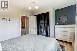 Recessed lighting, wood-finish flooring, two-panel interior doors, and a gold-tone semi-flush mount light fixture - 