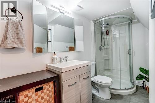 Compact bathroom featuring a corner shower enclosure, white vanity with integrated sink, dual-door mirrored medicine cabinet, and a wall-mounted light fixture - 2488 Brookhurst Road, Mississauga, ON - Indoor Photo Showing Bathroom