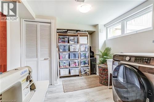 Laminate wood-finish flooring, two upper windows, and a ceiling-mounted light fixture - 2488 Brookhurst Road, Mississauga, ON - Indoor Photo Showing Laundry Room