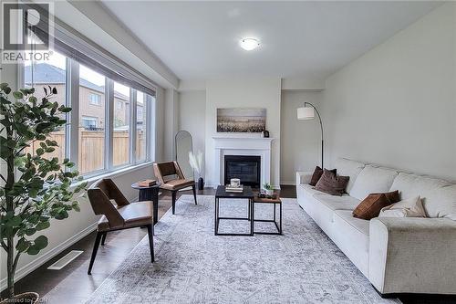 Expansive window array, wood-finish flooring, recessed lighting, and a prominent fireplace with a classic mantel - 11 Esther Crescent, Thorold, ON - Indoor Photo Showing Living Room With Fireplace