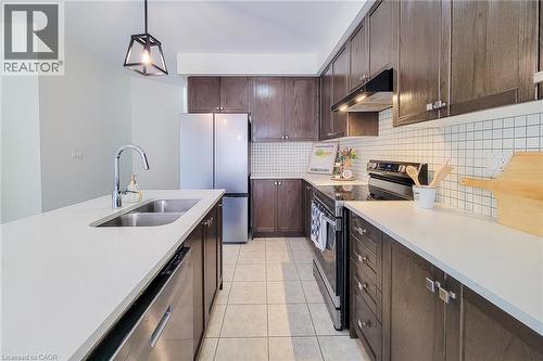 Kitchen featuring a double basin sink, dark wood-finish cabinetry, stainless steel appliances, and white square tile backsplash - 11 Esther Crescent, Thorold, ON - Indoor Photo Showing Kitchen With Stainless Steel Kitchen With Double Sink With Upgraded Kitchen