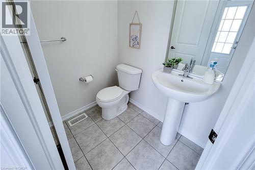 Pedestal sink with chrome faucet, toilet, and tile flooring - 11 Esther Crescent, Thorold, ON - Indoor Photo Showing Bathroom