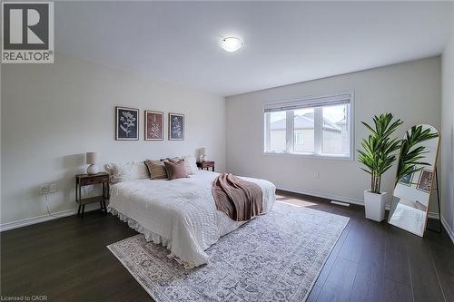 Wide plank wood-finish flooring, large window with blinds, ceiling-mounted light fixture, light-toned wall paint - 11 Esther Crescent, Thorold, ON - Indoor Photo Showing Bedroom