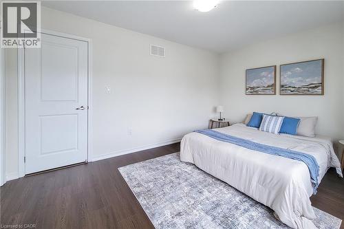 Wood-finish flooring with crisp white baseboards, a two-panel interior door, and overhead flush-mount lighting - 11 Esther Crescent, Thorold, ON - Indoor Photo Showing Bedroom