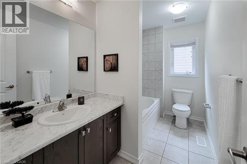 Bathroom featuring a single vanity with an undermount sink, dark wood-finish cabinetry, and a light-toned countertop - 11 Esther Crescent, Thorold, ON - Indoor Photo Showing Bathroom