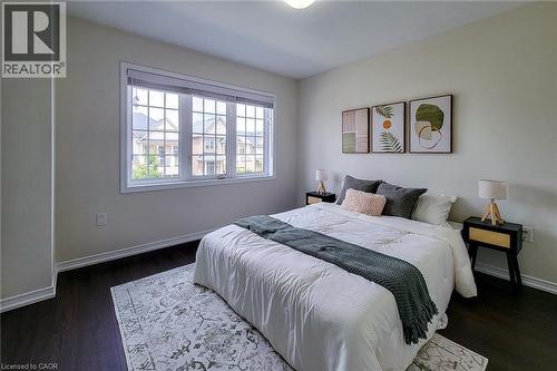 White walls, dark wood-finish flooring, and a large multi-pane window - 11 Esther Crescent, Thorold, ON - Indoor Photo Showing Bedroom