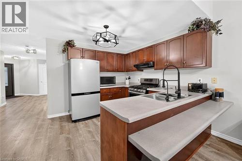 Kitchen featuring wood-finish cabinetry, light-toned countertops, and stainless steel appliances - 43 Liam Drive, Ancaster, ON - Indoor Photo Showing Kitchen