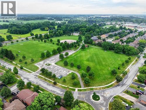 Expansive green spaces and mature trees surround residential properties, featuring paved roadways and a traffic circle - 43 Liam Drive, Ancaster, ON - Outdoor With View