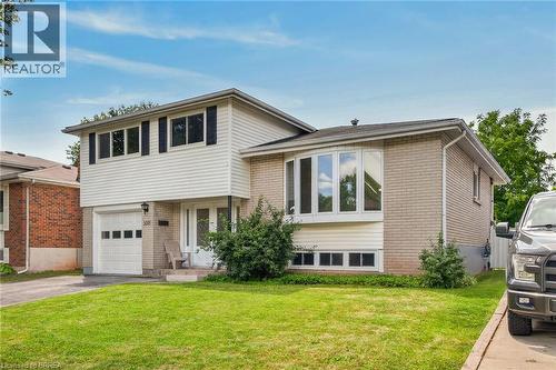 Split-level residence featuring a brick facade, white siding, and a single-car garage - 5371 Riverside Drive, Burlington, ON - Outdoor
