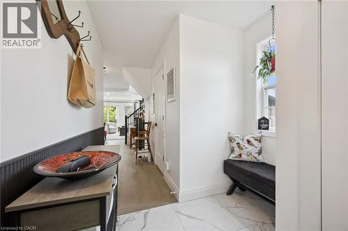 Entryway featuring white marble-look tile, wood-finish flooring, a built-in window bench, and wainscoting - 439 Beaver Creek Road, Waterloo, ON - Indoor Photo Showing Other Room