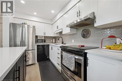 Kitchen featuring white cabinetry, stainless steel appliances, light-toned countertops, and a gray tile backsplash - 439 Beaver Creek Road, Waterloo, ON - Indoor Photo Showing Kitchen With Upgraded Kitchen