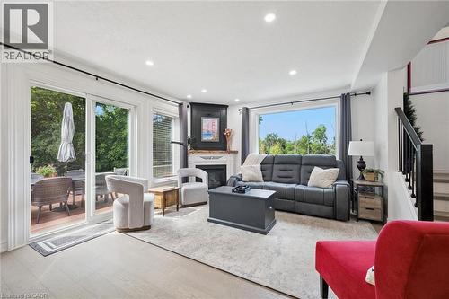 Recessed lighting illuminates the open living space, featuring wood-finish flooring and a central fireplace with a dark mantel - 439 Beaver Creek Road, Waterloo, ON - Indoor Photo Showing Living Room