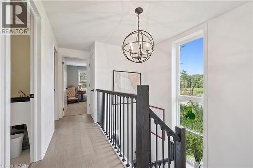 Hardwood-finish flooring, white walls, and a black metal chandelier - 439 Beaver Creek Road, Waterloo, ON - Indoor Photo Showing Other Room