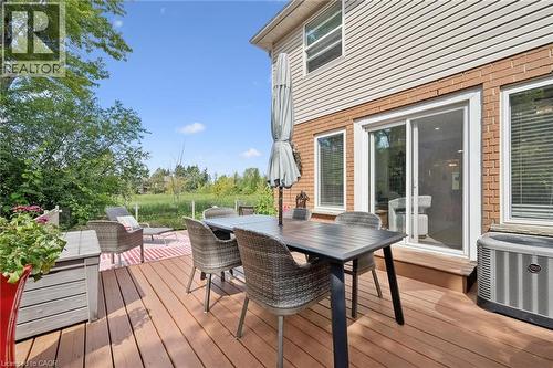 Expansive wood-finish deck with a sliding glass door and brick exterior - 439 Beaver Creek Road, Waterloo, ON - Outdoor With Deck Patio Veranda With Exterior