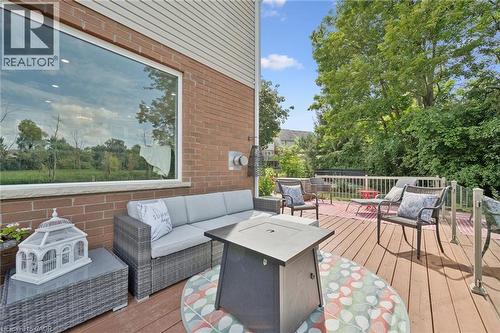 Expansive wood deck with white railings, brick exterior, and a large rectangular window - 439 Beaver Creek Road, Waterloo, ON - Outdoor With Deck Patio Veranda With Exterior
