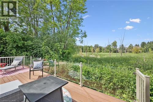 Expansive outdoor deck with wood-finish flooring, glass railing, and a natural landscape beyond - 439 Beaver Creek Road, Waterloo, ON - Outdoor With Deck Patio Veranda