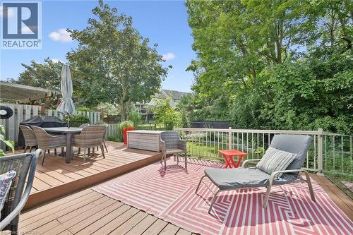 Multi-level wood deck with white metal railings, surrounded by mature trees and lush foliage - 439 Beaver Creek Road, Waterloo, ON - Outdoor With Deck Patio Veranda With Exterior