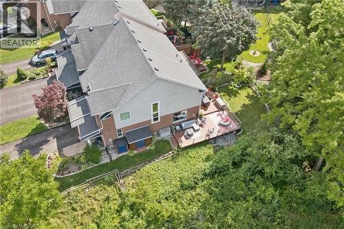 Expansive rear deck, multi-level property architecture, pitched shingle roof, paved driveway, and established landscaping - 439 Beaver Creek Road, Waterloo, ON - Outdoor With View