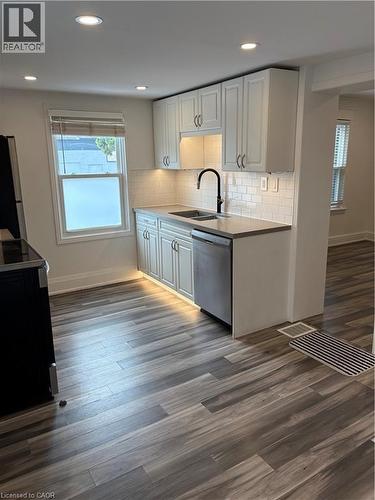 Kitchen with range, dark wood-style flooring, dishwashing machine, recessed lighting, and white cabinetry - 1090 Cannon Street E Unit# 2, Hamilton, ON - Indoor Photo Showing Kitchen