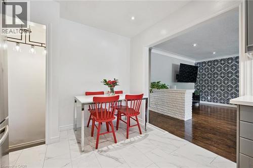 White tiled flooring, recessed lighting, and a wide entryway leading to an additional space featuring wood-finish flooring and a decorative wall - 49 East Street, Cambridge, ON - Indoor