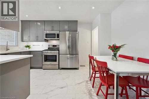 Modern kitchen featuring gray cabinetry, stainless steel appliances, white tile flooring, and recessed lighting - 49 East Street, Cambridge, ON - Indoor