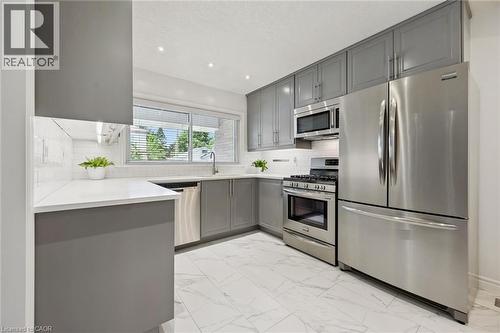 Kitchen featuring gray cabinetry, stainless steel appliances, white countertops, and white subway tile backsplash - 49 East Street, Cambridge, ON - Indoor Photo Showing Kitchen With Stainless Steel Kitchen With Upgraded Kitchen