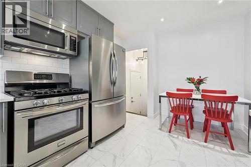 Kitchen featuring stainless steel appliances, white subway tile backsplash, gray cabinetry, and white tile flooring - 49 East Street, Cambridge, ON - Indoor Photo Showing Kitchen With Stainless Steel Kitchen