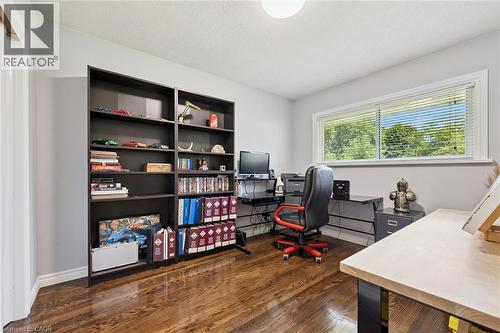 Rich wood-finish flooring with a rectangular window featuring horizontal blinds - 49 East Street, Cambridge, ON - Indoor Photo Showing Office