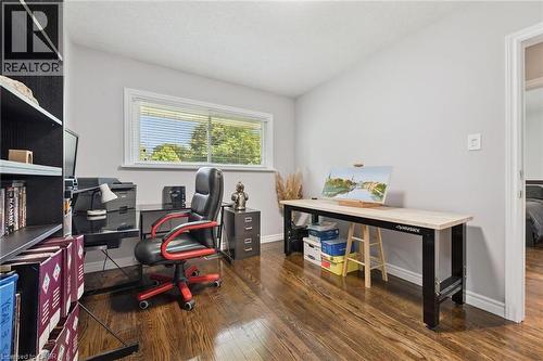 Wood-finish flooring, light gray wall paint, built-in shelving, and a white window with horizontal blinds - 49 East Street, Cambridge, ON - Indoor Photo Showing Office