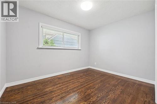 Hardwood flooring, light gray walls, white trim, recessed lighting, and a single window with blinds - 49 East Street, Cambridge, ON - Indoor Photo Showing Other Room
